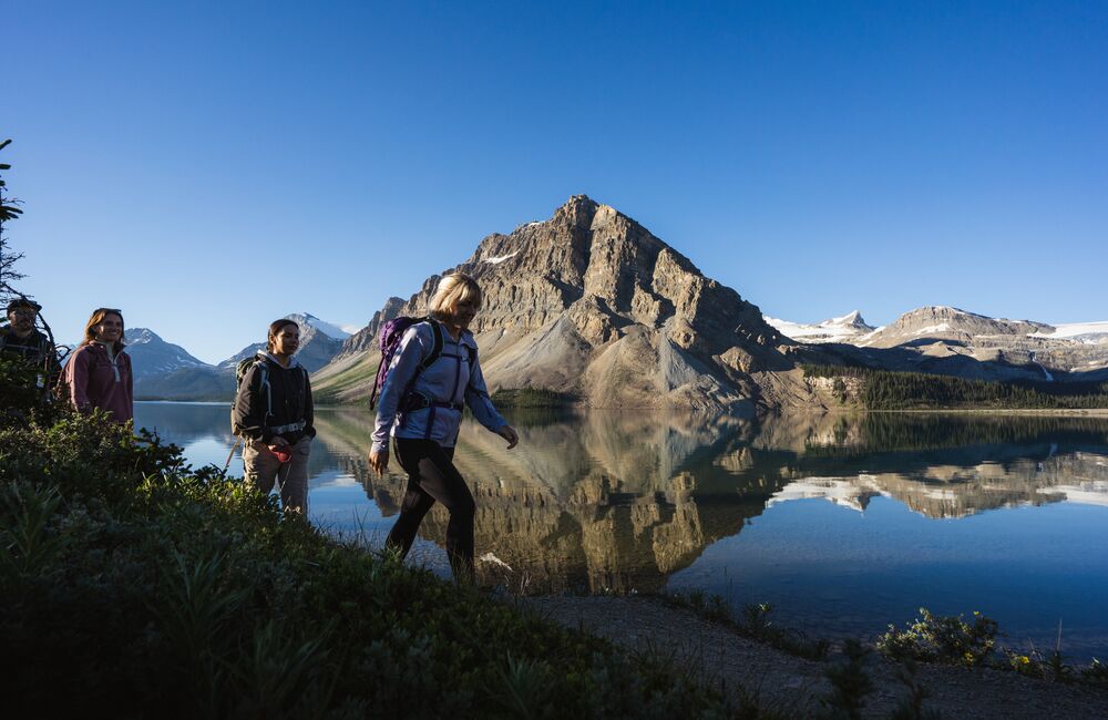 A group of friends walk beside Bow Lake on the Icefields Parkway in Banff National Park.